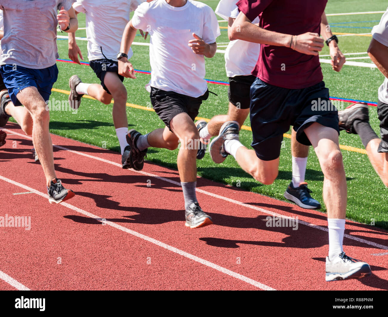 Une équipe de cross-country les garçons en marche alors que rapide dans un groupe, sur une piste, à la pratique. Banque D'Images
