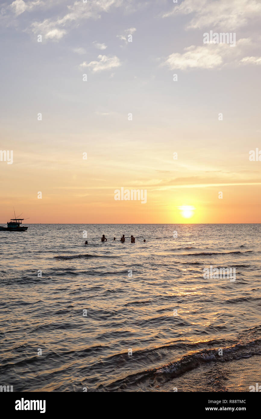 Les enfants jouent dans la mer au coucher du soleil sur l'île de Phu Quoc au Vietnam Banque D'Images