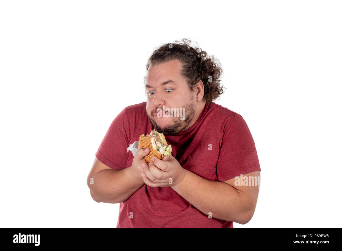 Funny fat man eating hamburger. Restauration rapide, unhealty manger Banque D'Images