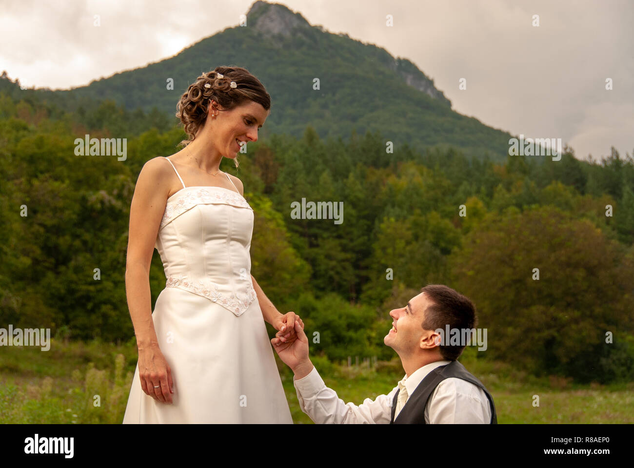 Homme de race blanche à genoux demandant à son épouse de l'épouser devant la montagne en Slovaquie Banque D'Images