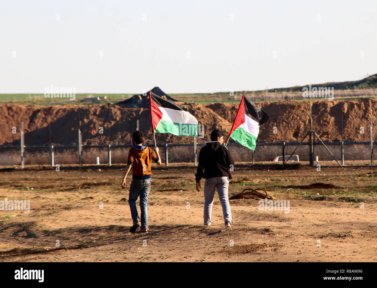 La jeunesse palestinienne vu holding Palestine drapeaux lors d'affrontements entre les citoyens palestiniens et les forces israéliennes dans le nord de la bande de Gaza au cours d'une manifestation contre la reconnaissance de l'Atout, le président des États-Unis Jérusalem comme capitale d'Israël. Banque D'Images