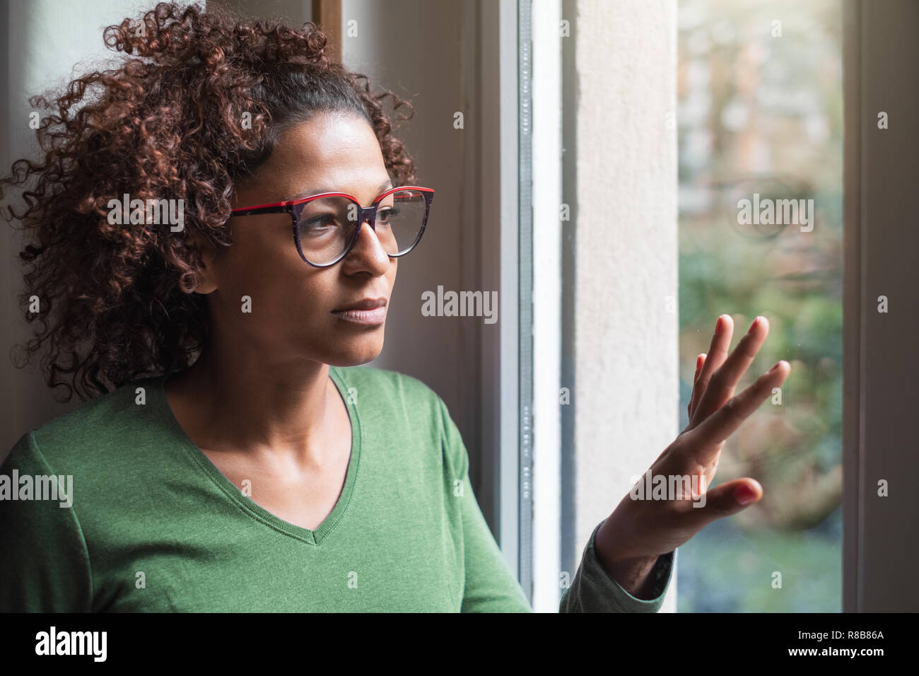 Triste african american girl en regardant par la fenêtre Banque D'Images