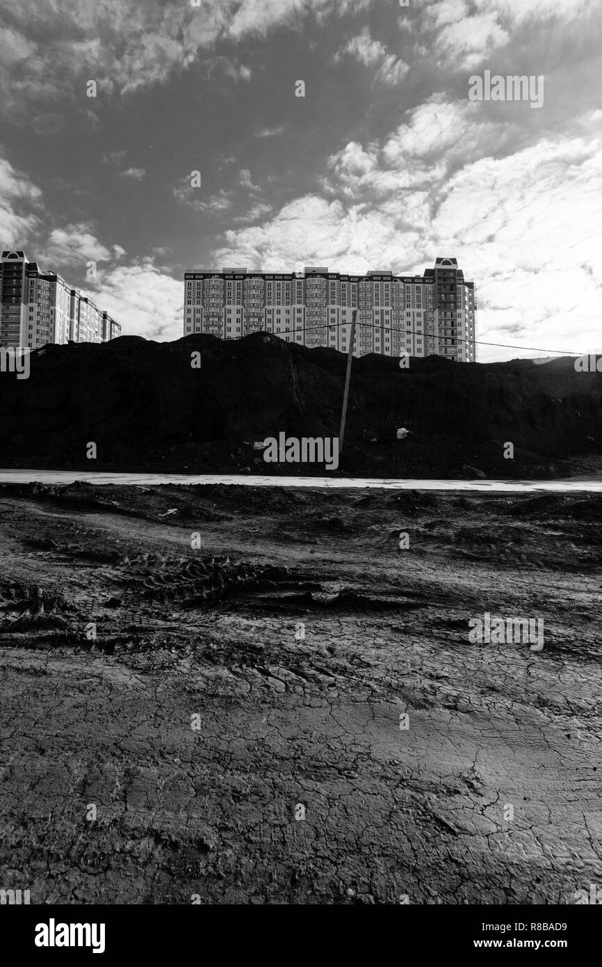 Vue du nouveau bâtiment résidentiel de plusieurs étages, debout sur le bord du site de construction. Photo en noir et blanc. Banque D'Images Vue du nouveau bâtiment résidentiel de plusieurs étages, debout sur le bord du site de construction. Photo en noir et blanc. Banque D'Images