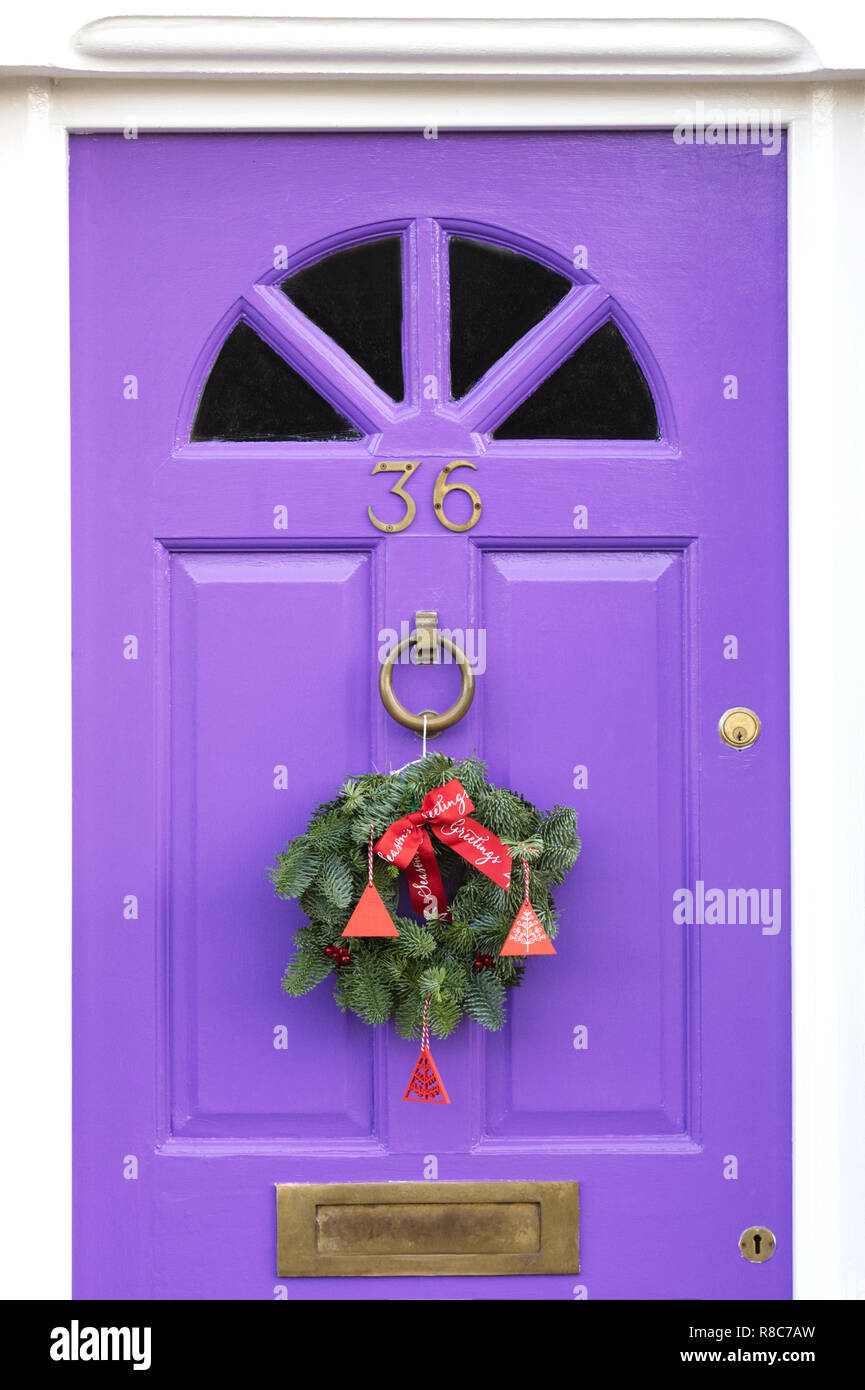 Couronne de Noël décoratif suspendu à une porte avant de couleur lilas. Banque D'Images