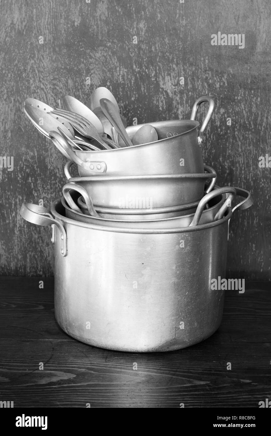 Les ustensiles de cuisine sont en aluminium anciens casseroles, plats, cuillers, fourchettes. Image noir et blanc Banque D'Images