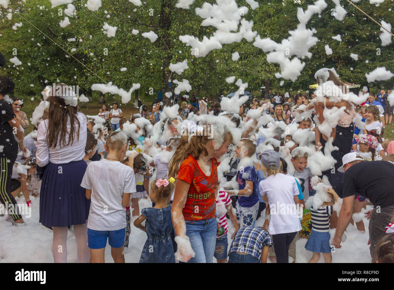 Kamennomostsky, Russie - septembre 1, 2018 : Heureux les enfants s'amusant lors d'une partie de mousse lors d'une maison de ville journée dans un parc d'automne Banque D'Images