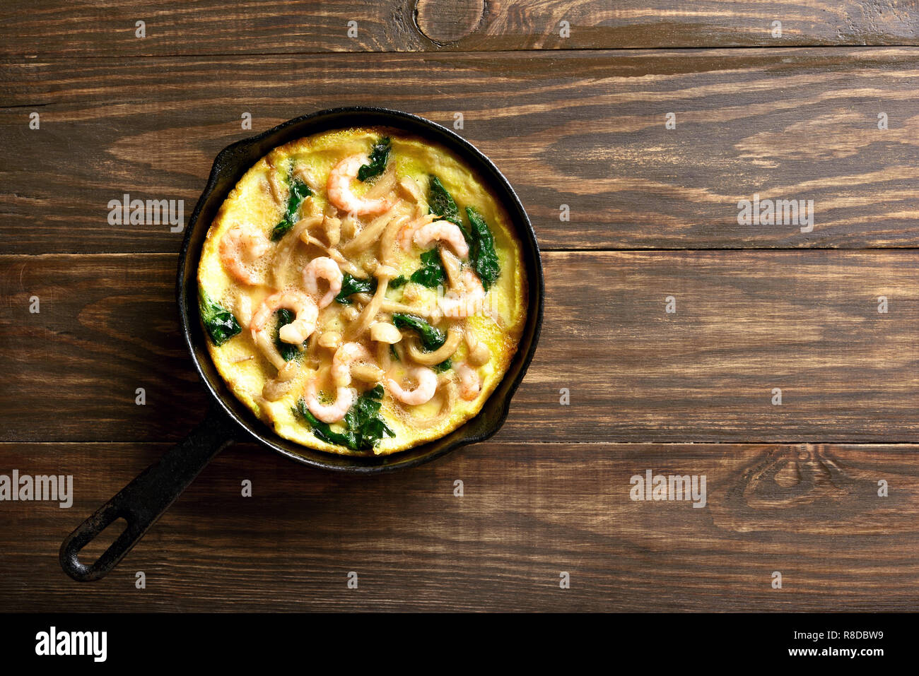 Frittata aux épinards et champignons aux crevettes à frire sur fond de bois avec l'exemplaire de l'espace. Haut de la vue, télévision lay Banque D'Images