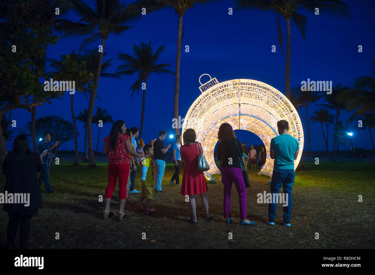 MIAMI - DÉCEMBRE, 2017 : Les visiteurs se réunissent pour prendre des photos en face d'un gigantesque sapin noël ornement situé dans les palmiers de Lummus Park. Banque D'Images