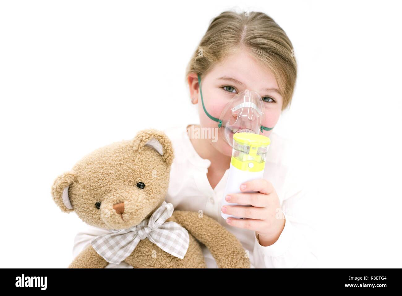 Jeune fille à l'aide de teddy bear pour inhalation par nébuliseur. Banque D'Images