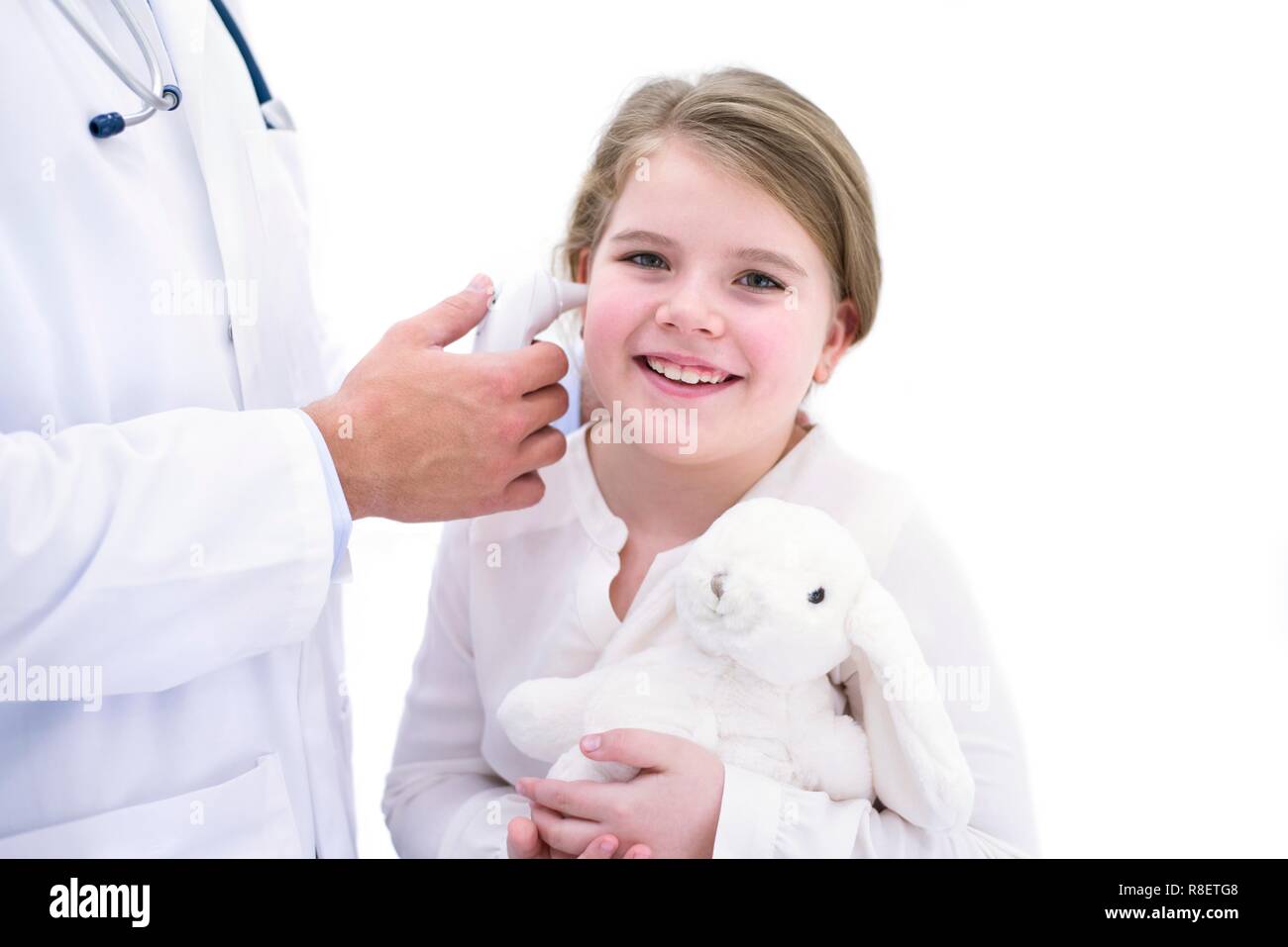 Médecin de prendre la température de la jeune fille à l'aide d'un thermomètre digital Banque D'Images