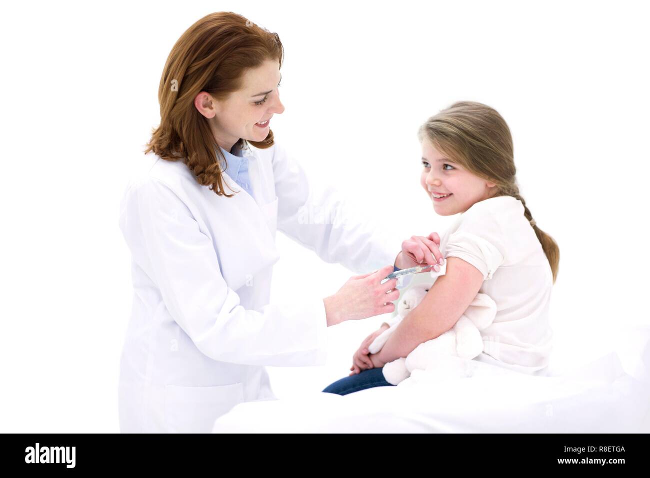 Médecin femme jeune fille par injection dans le bras. Banque D'Images