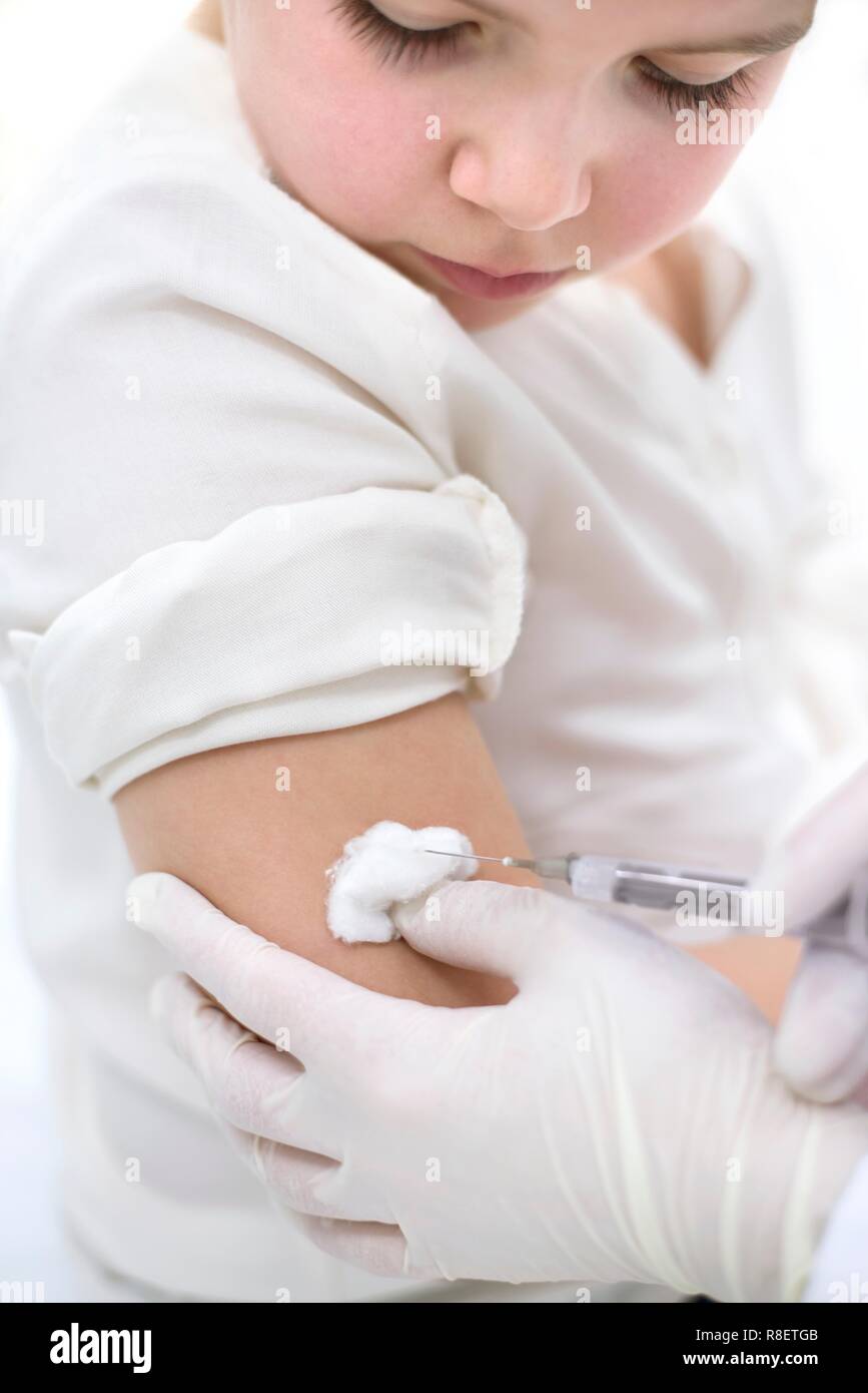 Doctor holding coton sur le bras de jeune fille après l'injection. Banque D'Images