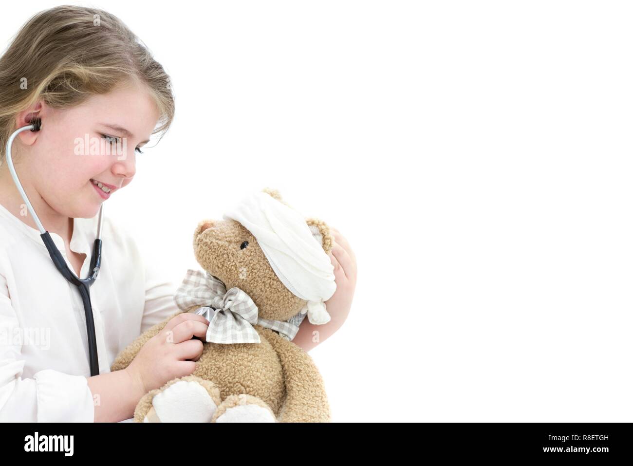 Jeune fille jouant avec l'ours en peluche et stéthoscope. Banque D'Images