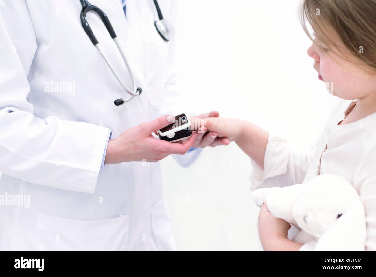 Médecin mise sur l'oxymètre de pouls doigt de la jeune fille. Banque D'Images