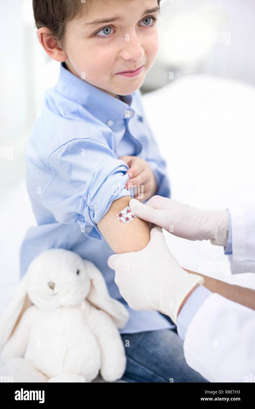 Médecin mettre le plâtre sur le bras du garçon après l'injection Banque D'Images