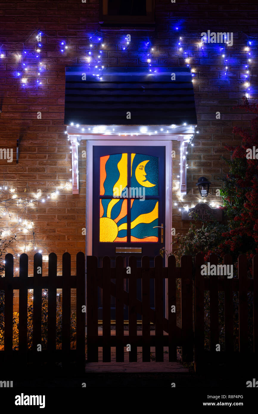 Soleil et lune porte en verre teinté et les lumières de Noël sur une maison à Bloxham. Bloxham, Oxfordshire, Angleterre Banque D'Images