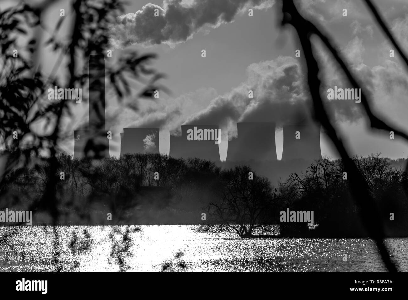 Une centrale électrique de l'autre côté du lac ondulant out hugs panaches de fumée dans le ciel Banque D'Images