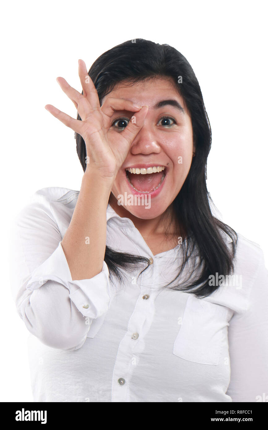 Photo image portrait d'un fier succès belle jeune femme d'Asie de l'air très heureux de voir à travers OK geste avec ses doigts Banque D'Images