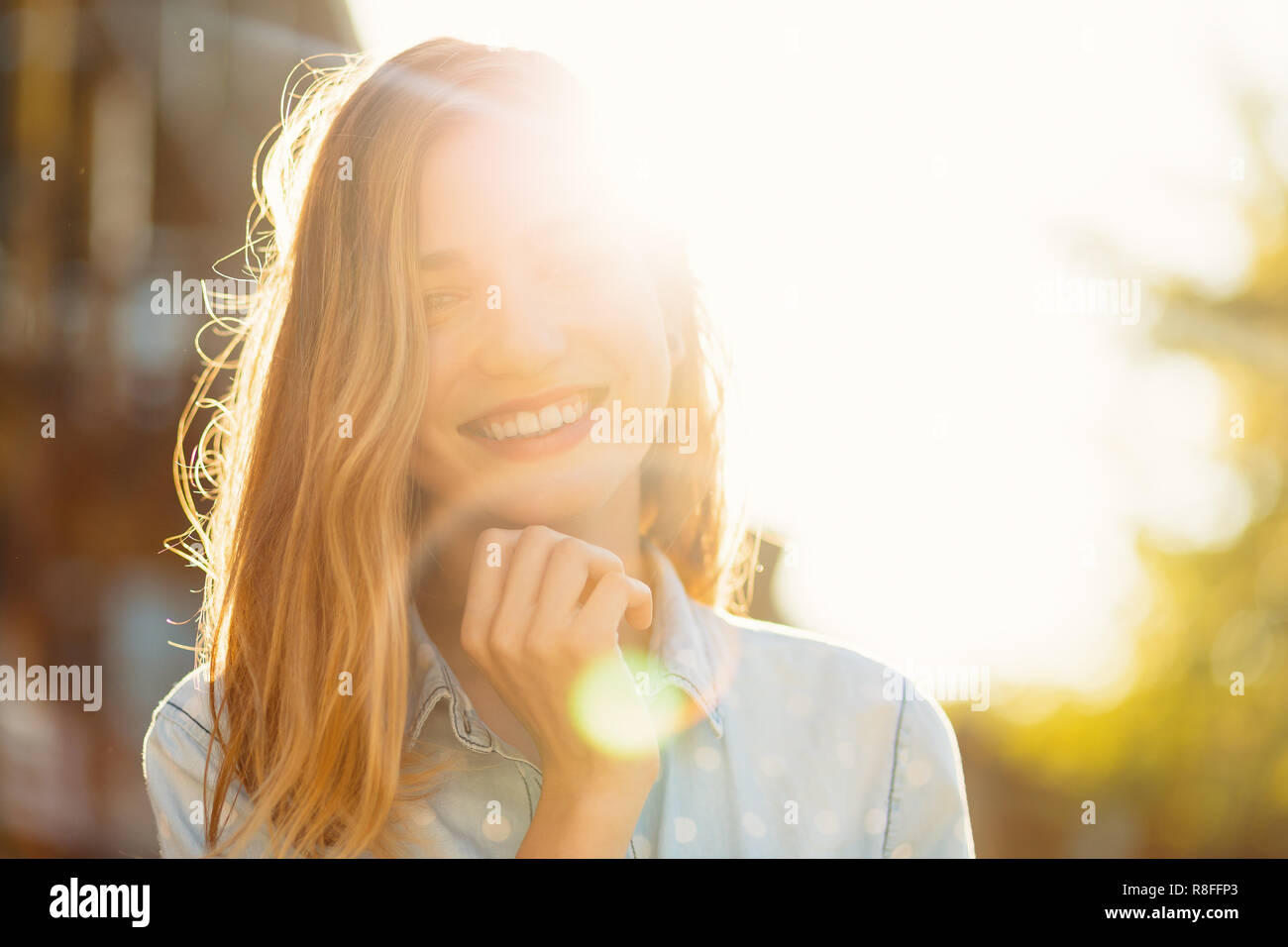 Magnifique Portrait fille avec un beau sourire et de beaux traits de visage sur une journée ensoleillée avec des rayons sur son visage. Douce, romantique, atmosphe Banque D'Images