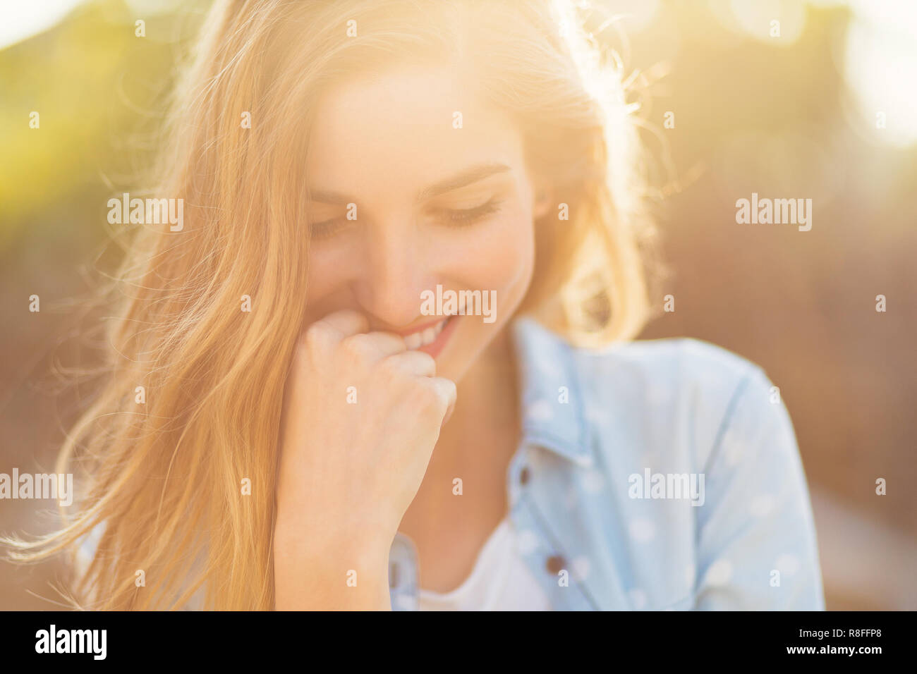 Magnifique Portrait fille avec un beau sourire et de beaux traits de visage sur une journée ensoleillée avec des rayons sur son visage. Douce, romantique, atmosphe Banque D'Images