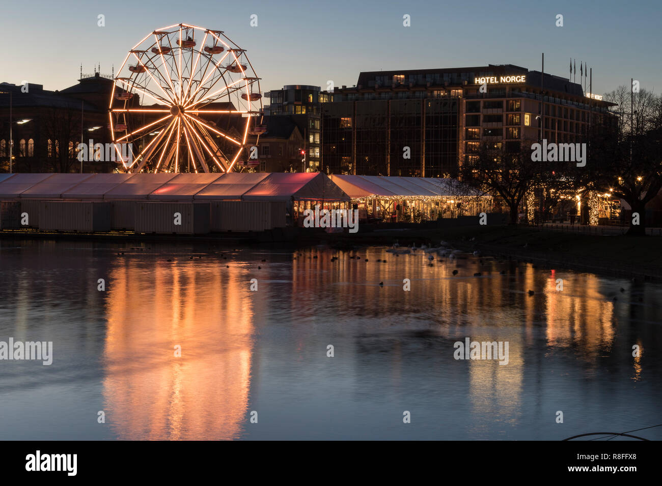 Marché de Noël par Lille Lungegaardsvannet Lake au centre-ville de Bergen, Norvège. Grande roue en rotation. Banque D'Images