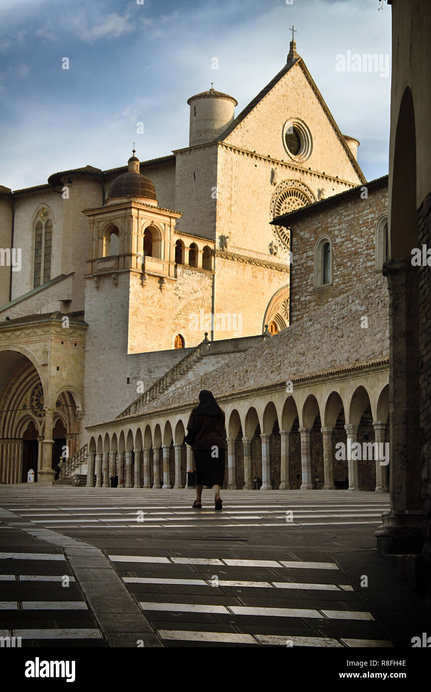 Une religieuse à marcher vers l'entrée de Saint François d'assise basilique. Banque D'Images