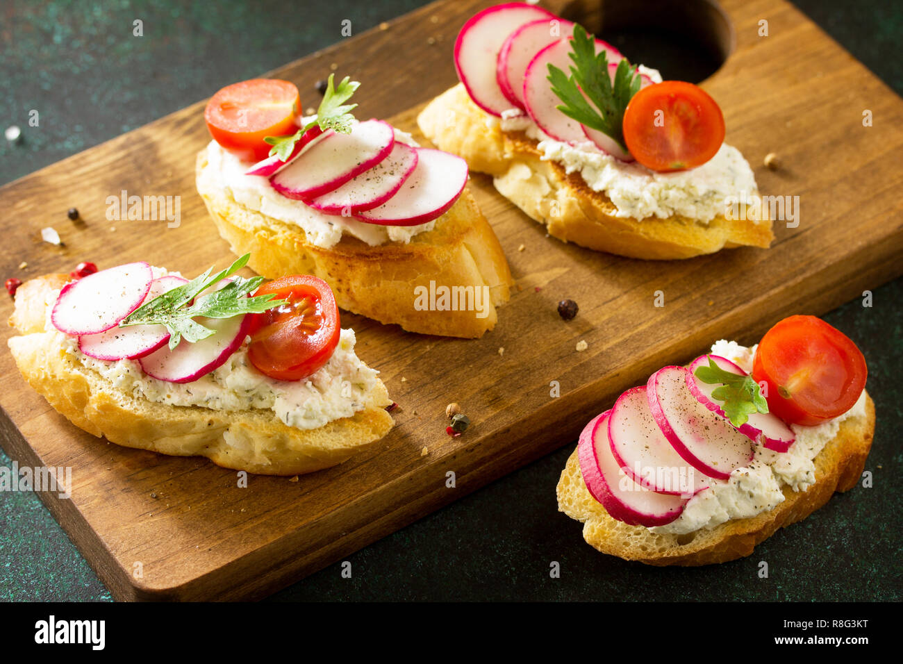 En-cas d'Antipasti définie pour le vin. Brushetta ou Crostini avec baguette grillées, fromage, radis et tomates servi sur une planche en bois rustique sur une pierre ta Banque D'Images