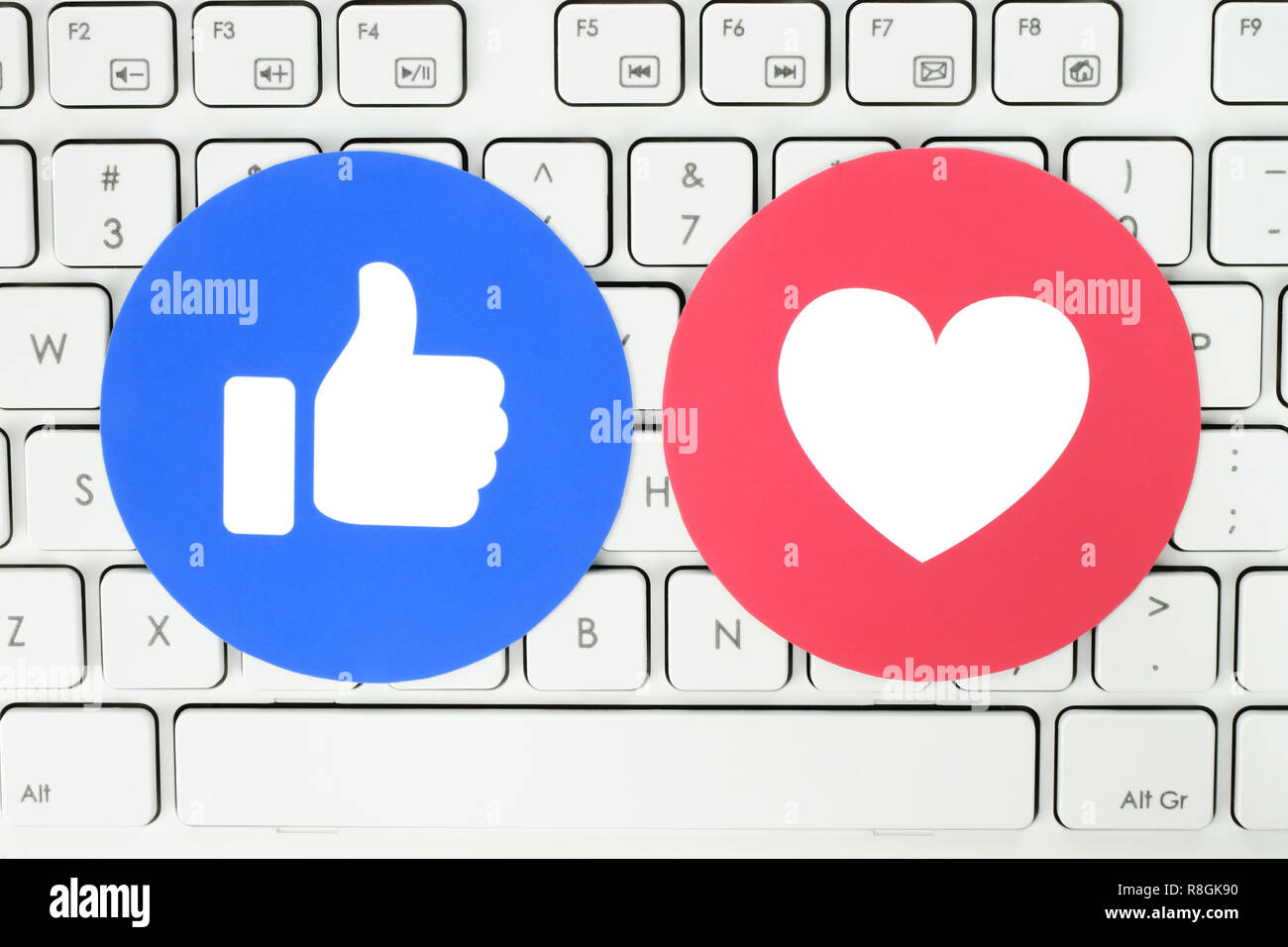 Kiev, Ukraine - le 28 novembre 2018 : comme Facebook et l'amour de bouton Réactions Emoji empathique imprimée sur du papier et mettre sur white keyboard Banque D'Images