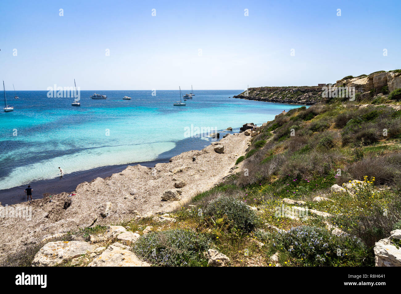 Seascape de Cala Azzurra, une petite plage de sable avec des eaux bleu azur et voiliers en arrière-plan, les îles Égades, Sicile, Italie Banque D'Images