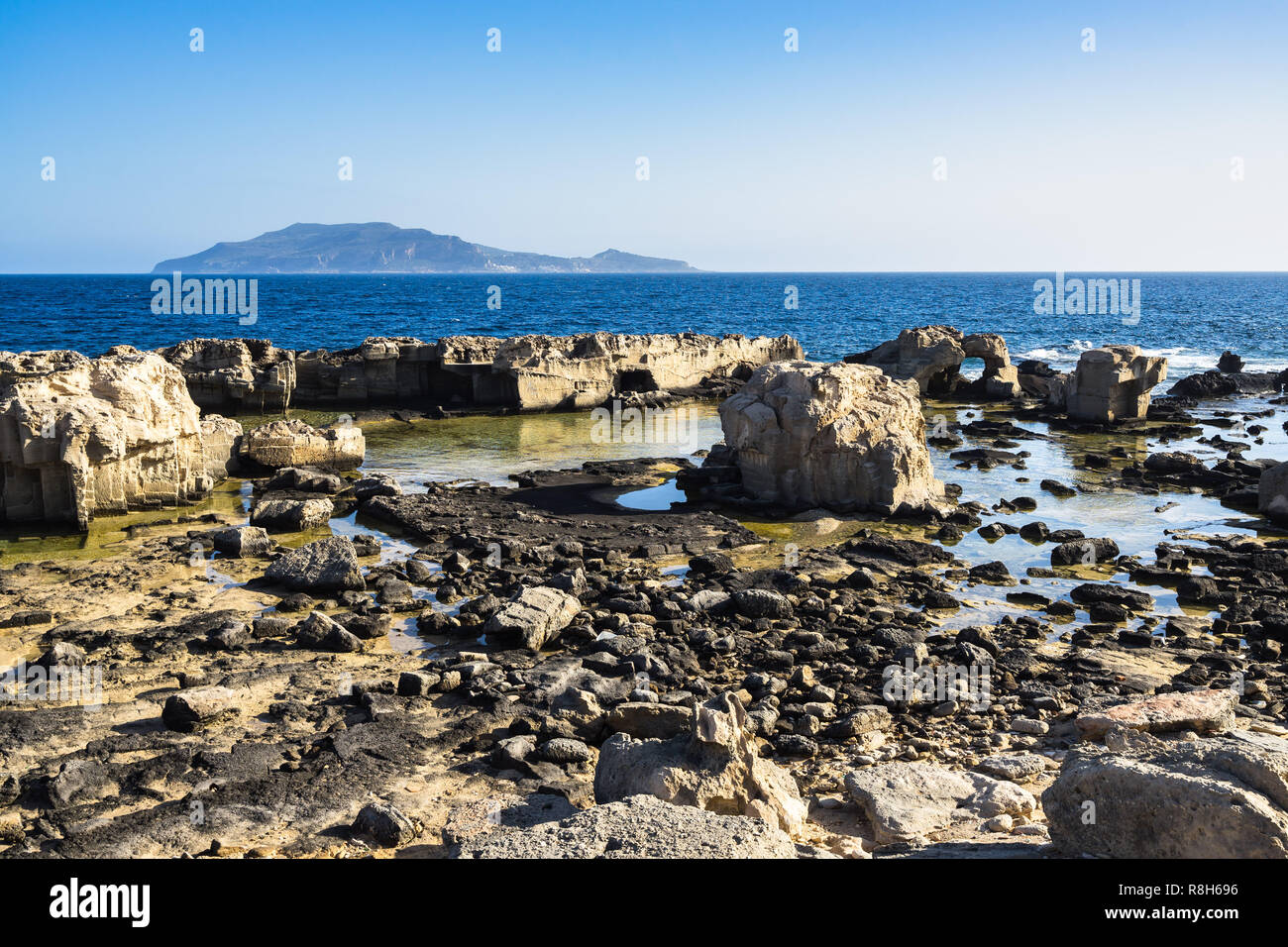 Scenic côte rocheuse de Favignana dans une journée ensoleillée de l'île de Levanzo en arrière-plan, les îles Égades, Sicile, Italie Banque D'Images