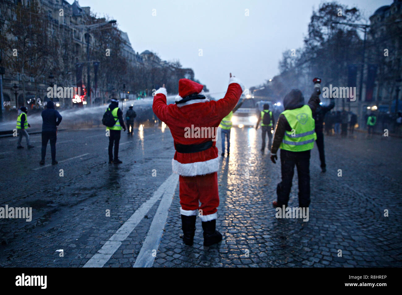Paris, France. 15 décembre 2018. La police anti-émeute utilise un canon à eau et des gaz lacrymogènes contre des manifestants au cours d'une manifestation contre la hausse du carburant et les prix du pétrole par des personnes portant des gilets jaunes. Credit : ALEXANDROS MICHAILIDIS/Alamy Live News Banque D'Images