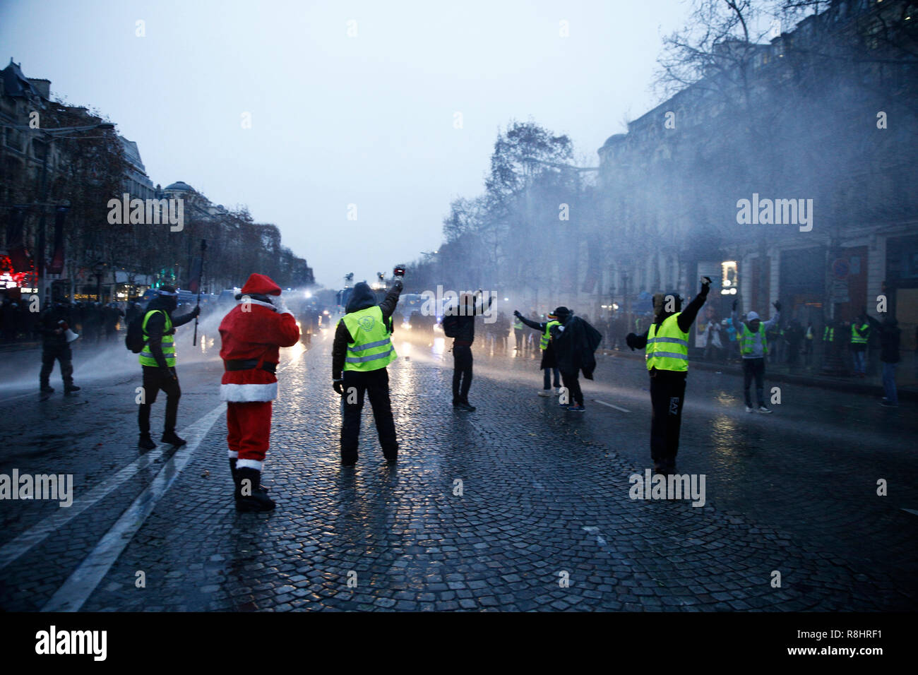 Paris, France. 15 décembre 2018. La police anti-émeute utilise un canon à eau et des gaz lacrymogènes contre des manifestants au cours d'une manifestation contre la hausse du carburant et les prix du pétrole par des personnes portant des gilets jaunes. Credit : ALEXANDROS MICHAILIDIS/Alamy Live News Banque D'Images