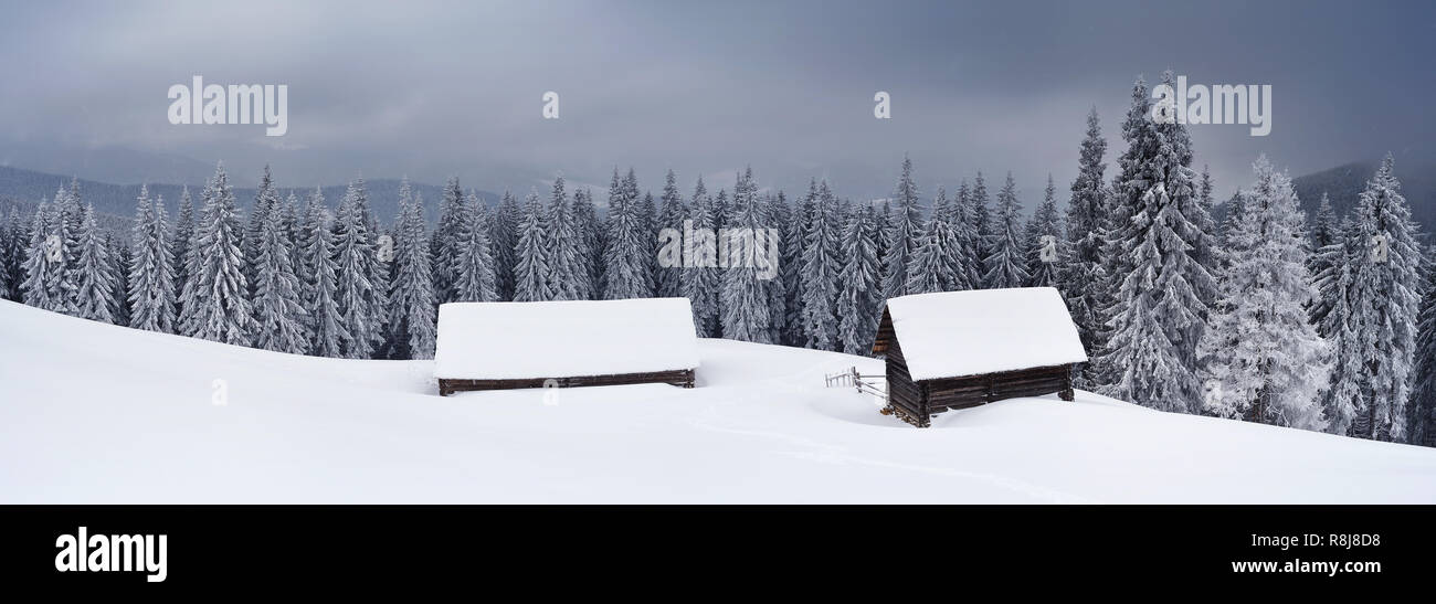 Panorama du paysage d'une vallée de montagne en hiver. Cabane et grange dans les montagnes sous le ciel de tempête. L'Ukraine, les Carpates, le ridge Kuk Banque D'Images