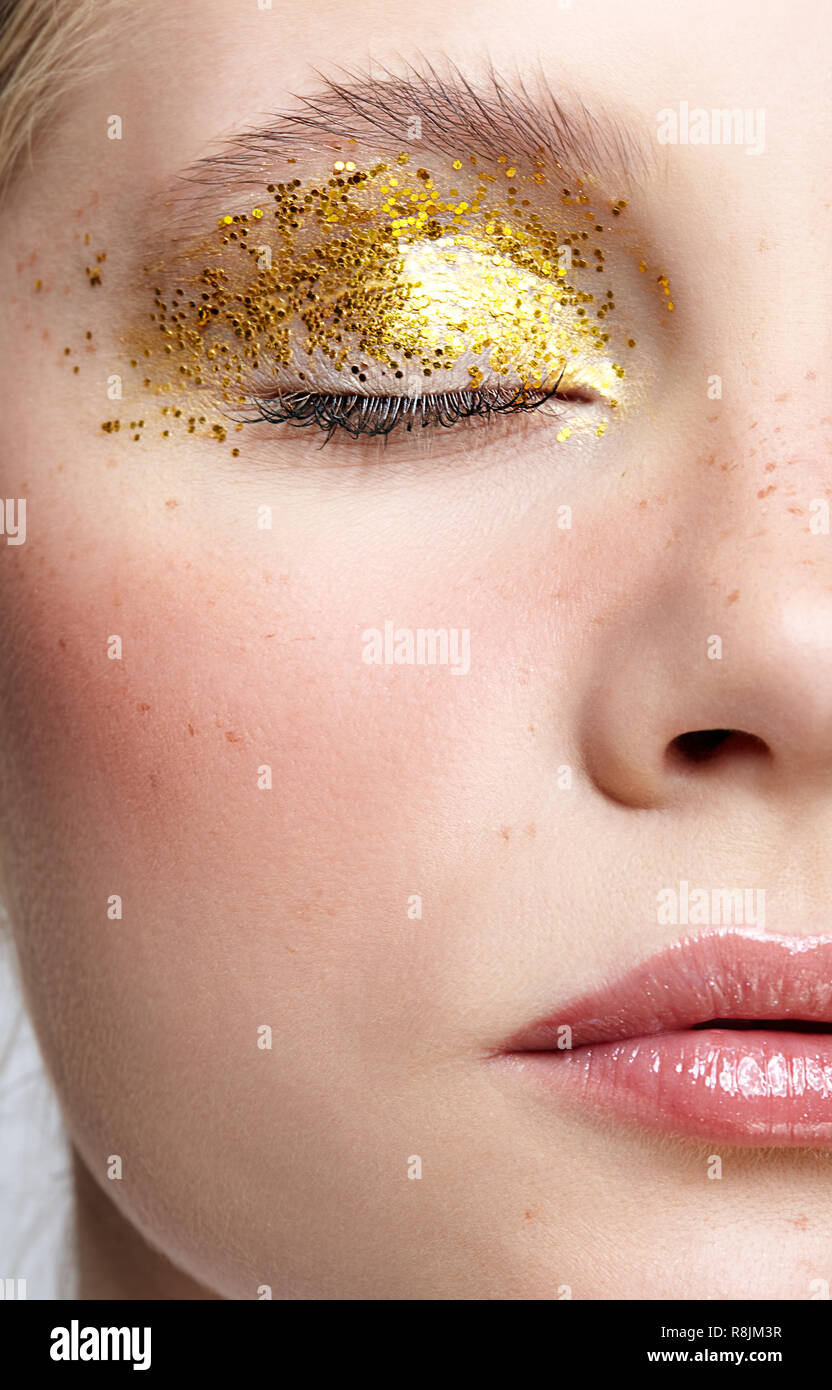 Closeup macro shot de la moitié féminine face avec les yeux fermés. Femme avec des paillettes robe vogue beauté visage maquillage. Fille avec une peau parfaite et Banque D'Images