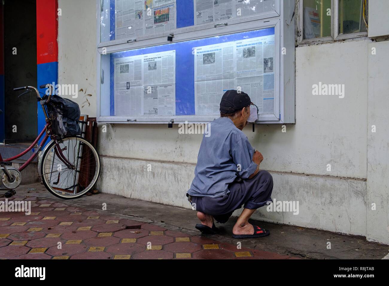 Vietnam, Hanoi, vieille ville, Man reading public news Banque D'Images