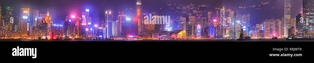 Nuit noire large panorama de Hong Kong city CBD autour du centre à travers le port de Victoria avec la réflexion des lumières et illuminations tour lumineuse Banque D'Images