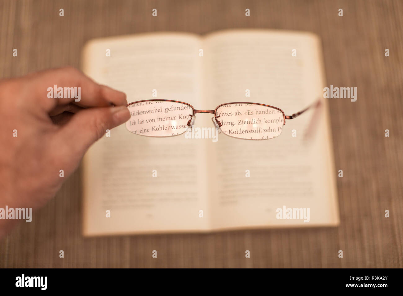 Hand holding eyeglasses rend les lettres d'une grande visibilité et une forte optique Banque D'Images