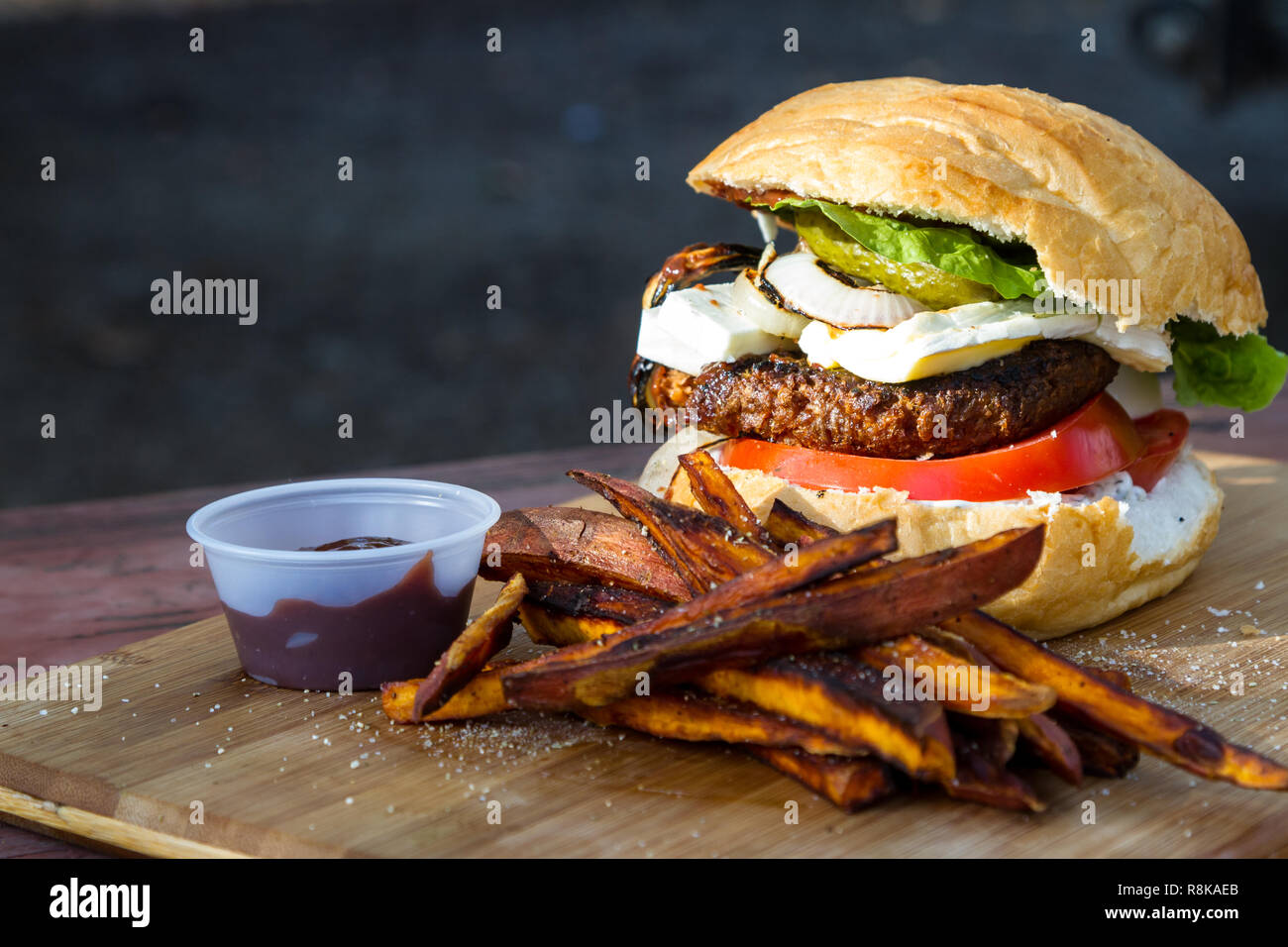 Burger à base de plante grillé servi avec une sauce faite maison frites de  patates douces sur une planche à découper en bois Photo Stock - Alamy