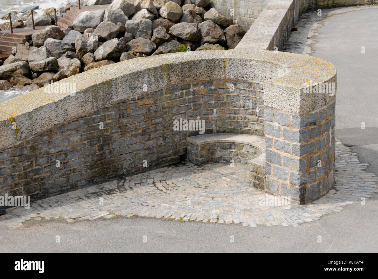 Pierre attrayante siège à sea wall, Lyme Regis, dans le Dorset, Angleterre Banque D'Images