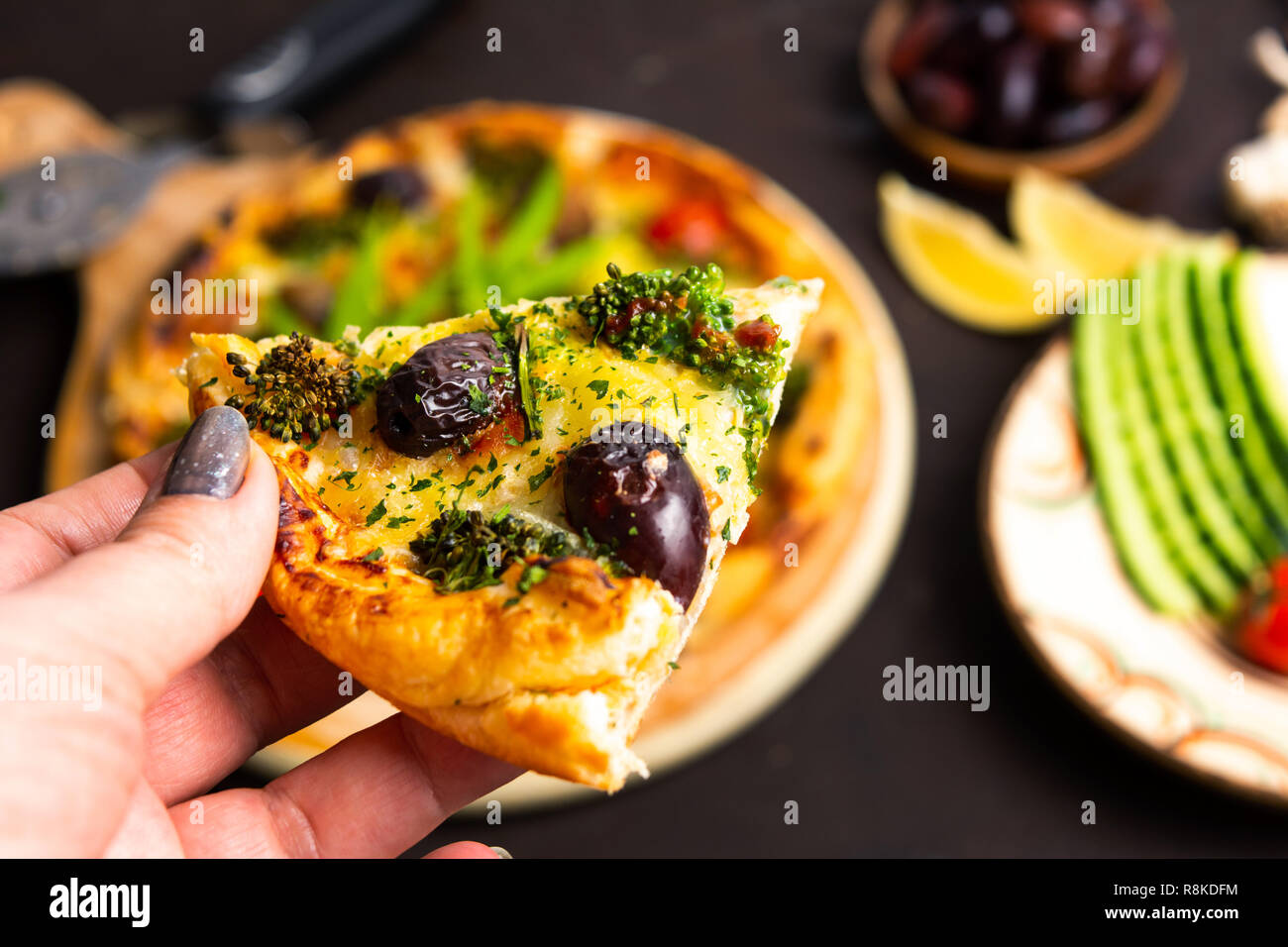 Woman holding pizza slice première personne Banque D'Images