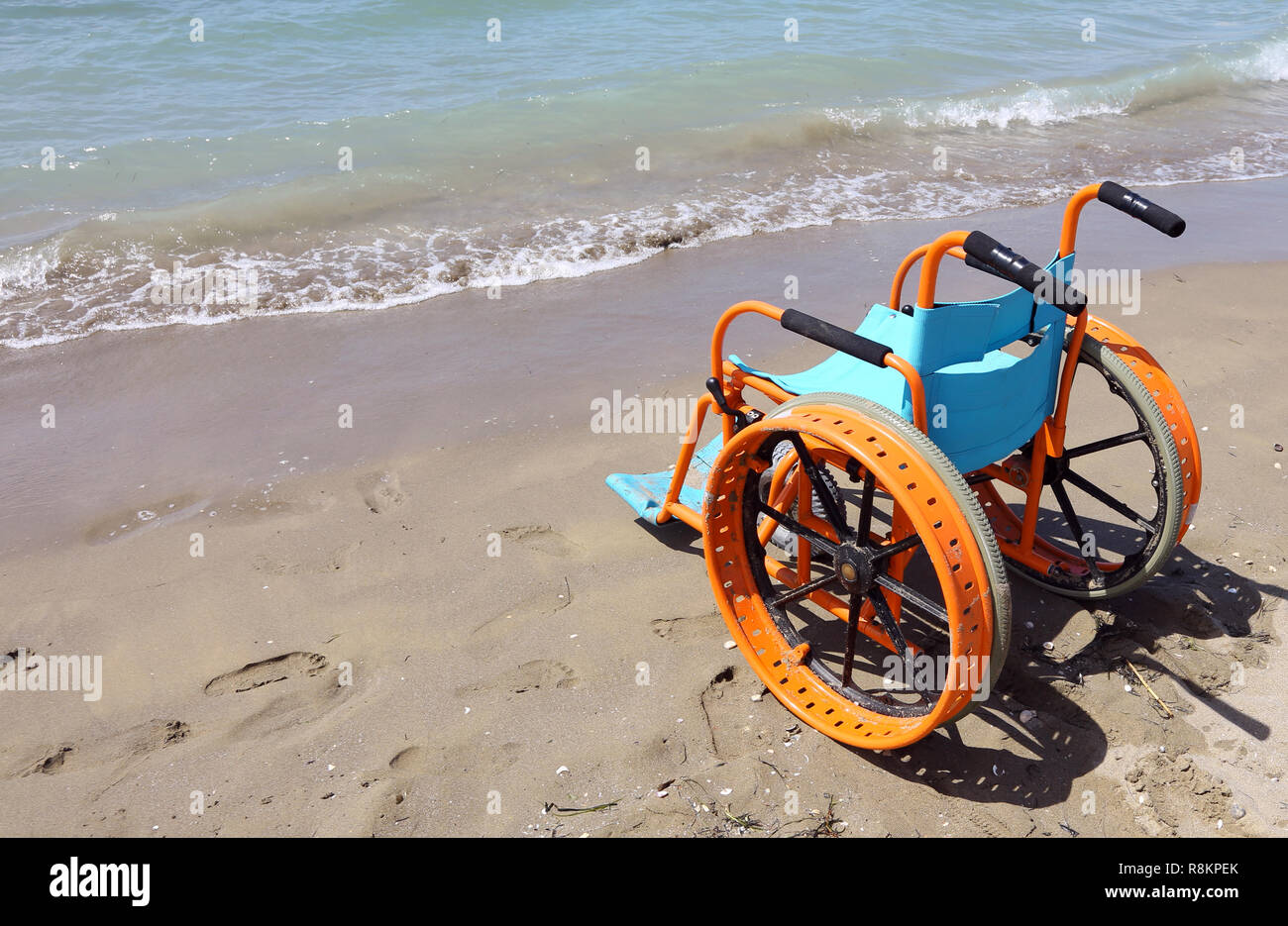 Fauteuil roulant spécial sur le sable de la plage avec de grosses roues  pour aller sur l'eau de la mer Photo Stock - Alamy