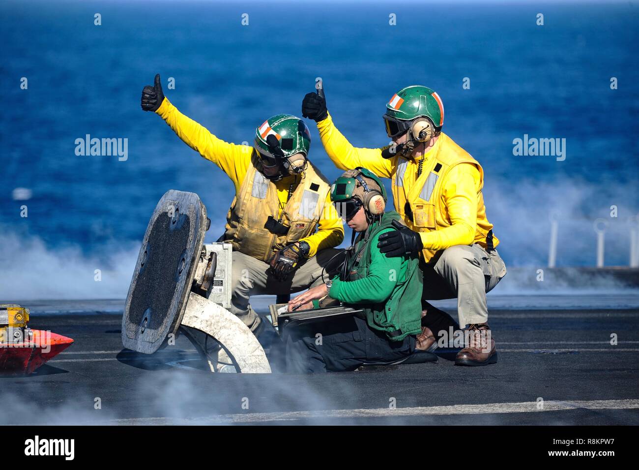 Les directeurs de vol connu comme chemises jaunes, un signal F/A-18 Super Hornet pour lancer à bord du poste de pilotage de la classe Nimitz porte-avions USS Harry S. Truman le 7 décembre 2018 dans l'océan Atlantique. Chemises jaunes sont portés par les gestionnaires d'aéronefs Aéronefs, administrateurs, officiers et catapulte Agents Arrêt considéré comme le plus difficile et important travail sur le poste de pilotage. Banque D'Images