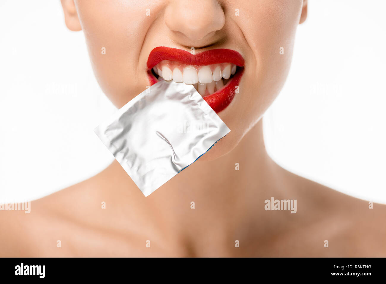 Cropped shot of young woman holding condom en dents isolated on white Banque D'Images