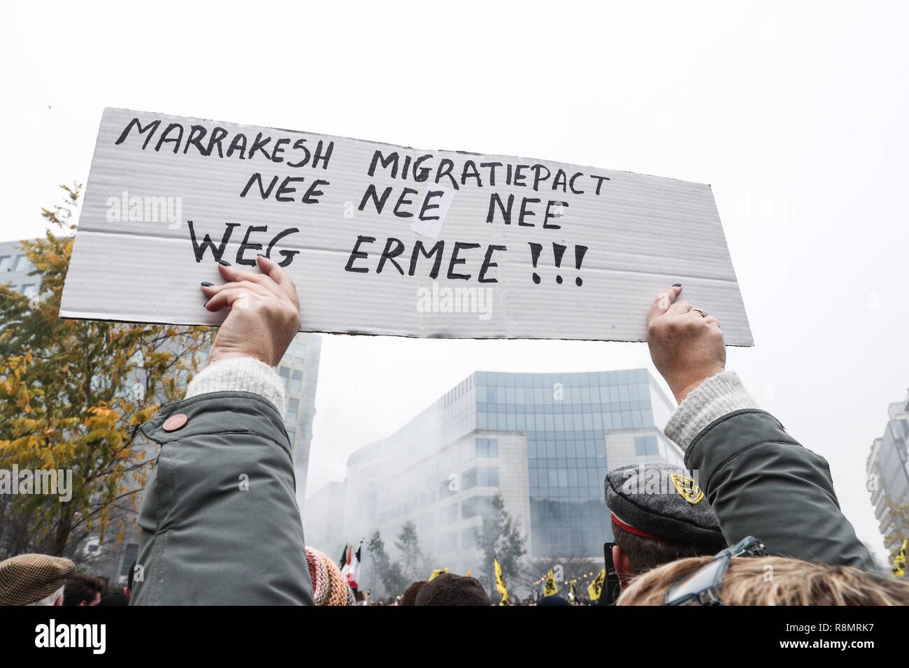 Bruxelles, Belgique. Dec 16, 2018. Un manifestant tient une bannière dénonçant un pacte mondial des Nations Unies pour les migrations au cours de la 'Marche contre Marrakech' rassemblement devant des institutions de l'Union européenne siège à Bruxelles, Belgique, 16 décembre 2018. Des manifestants anti-immigration belge sont descendus dans les rues de Bruxelles ici dimanche pour dénoncer le Pacte mondial pour l'utilisation sécuritaire, ordonné et la migration régulière adoptée à Marrakech, Maroc. Credit : Zheng Huansong/Xinhua/Alamy Live News Banque D'Images