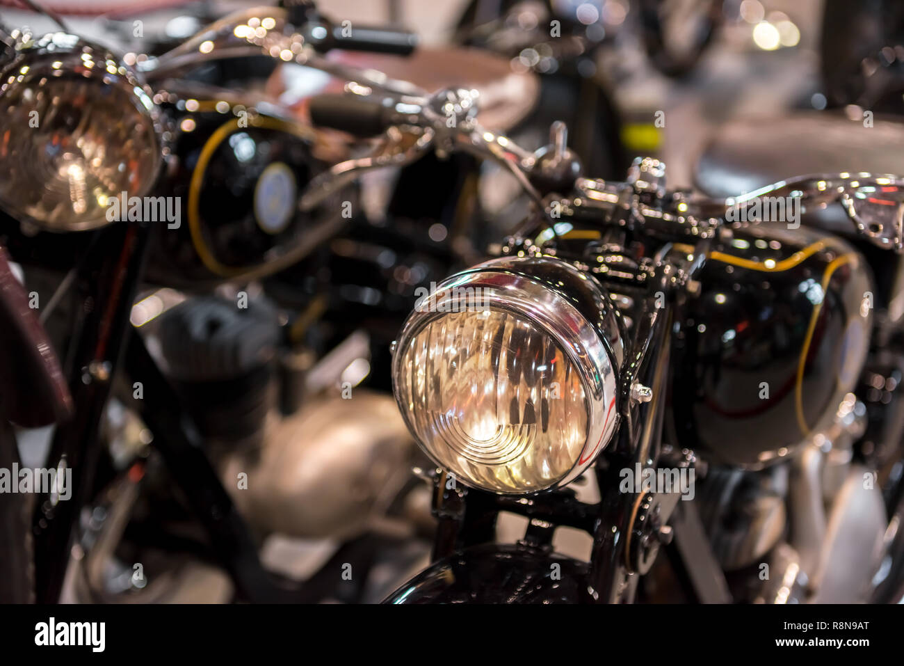 Selective focus point sur vintage lampe phare moto. Moto Retro avec phares avant sur fond flou. L'effet bokeh Banque D'Images