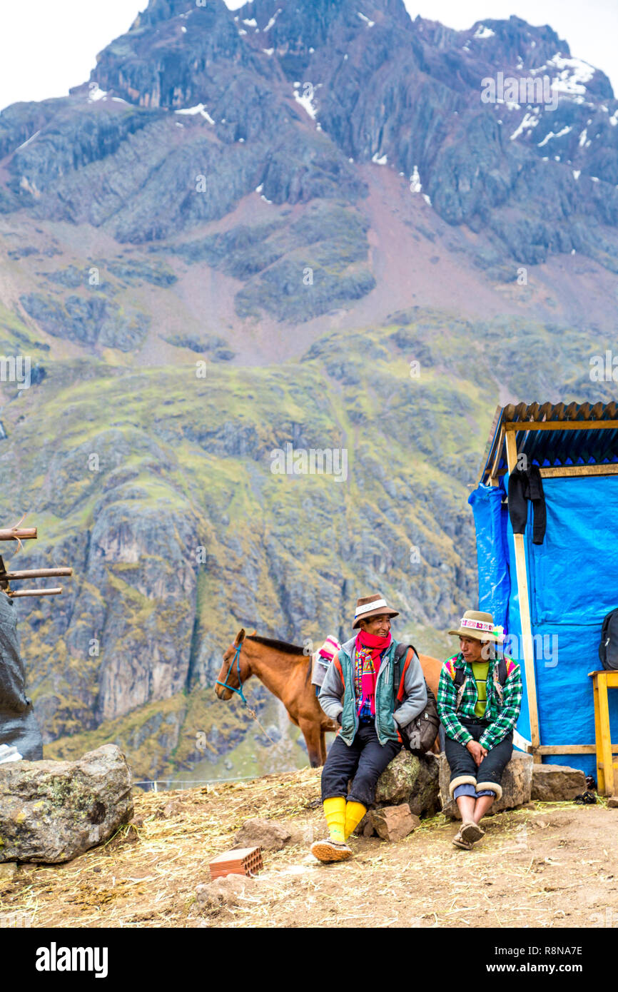 Deux péruviens talking and smiling avec un cheval et les montagnes en arrière-plan à la base de Rainbow Mountain (Vinicunca) Cusipata Trail, Andes, Pérou Banque D'Images