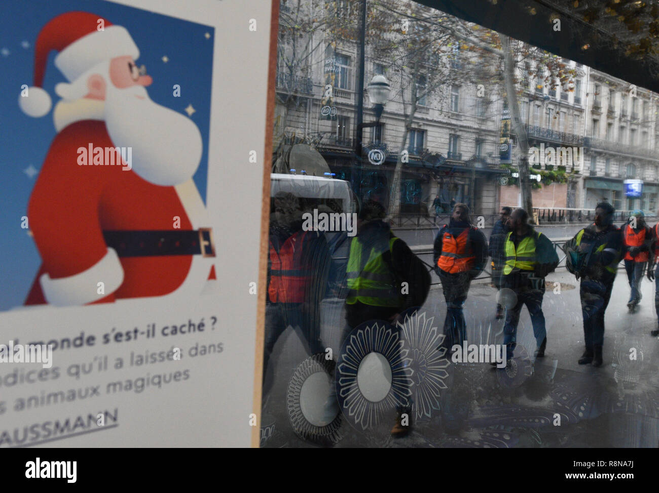 Décembre 08, 2018 - Paris, France : Gilet jaune protestataires se reflètent  dans les vitres de la boutique de luxe des Galeries Lafayette comme ils se  dirigent vers l'avenue des Champs-Élysées. Manifestation