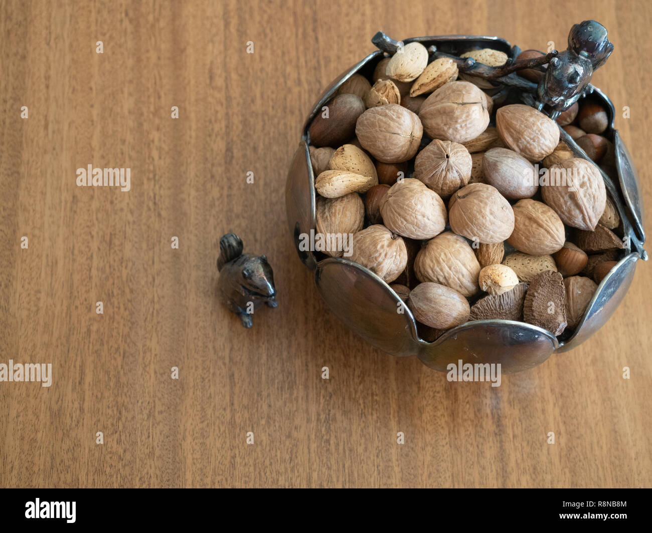 Bol en argent avec deux figurines d'Écureuil d'argent photographié sur une table en bois d'en haut. Bol contenues non mélangées. Banque D'Images