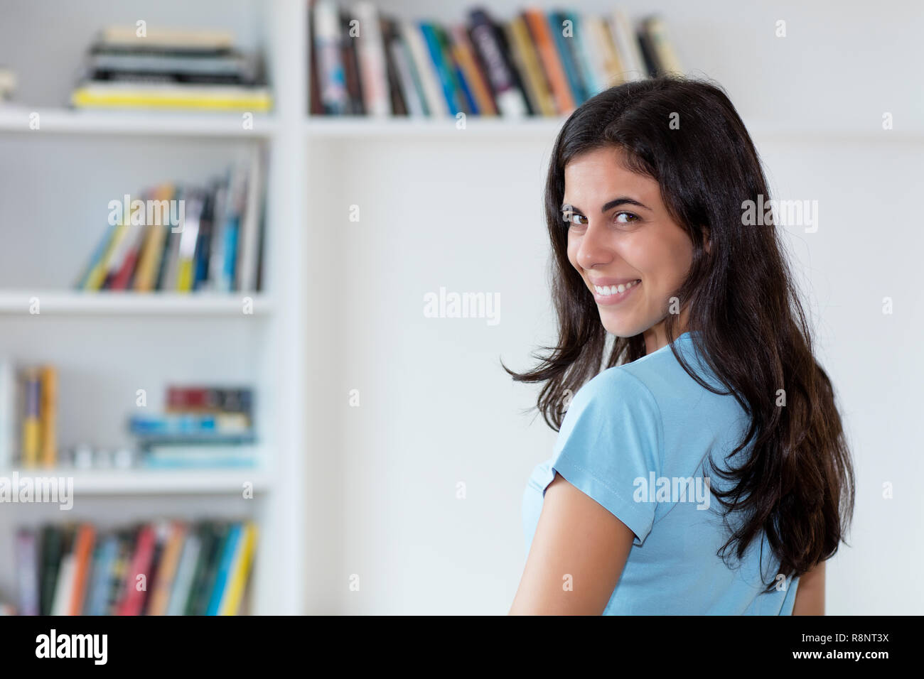 Rire l'arabe femme aux longs cheveux noirs à la maison à l'intérieur Banque D'Images