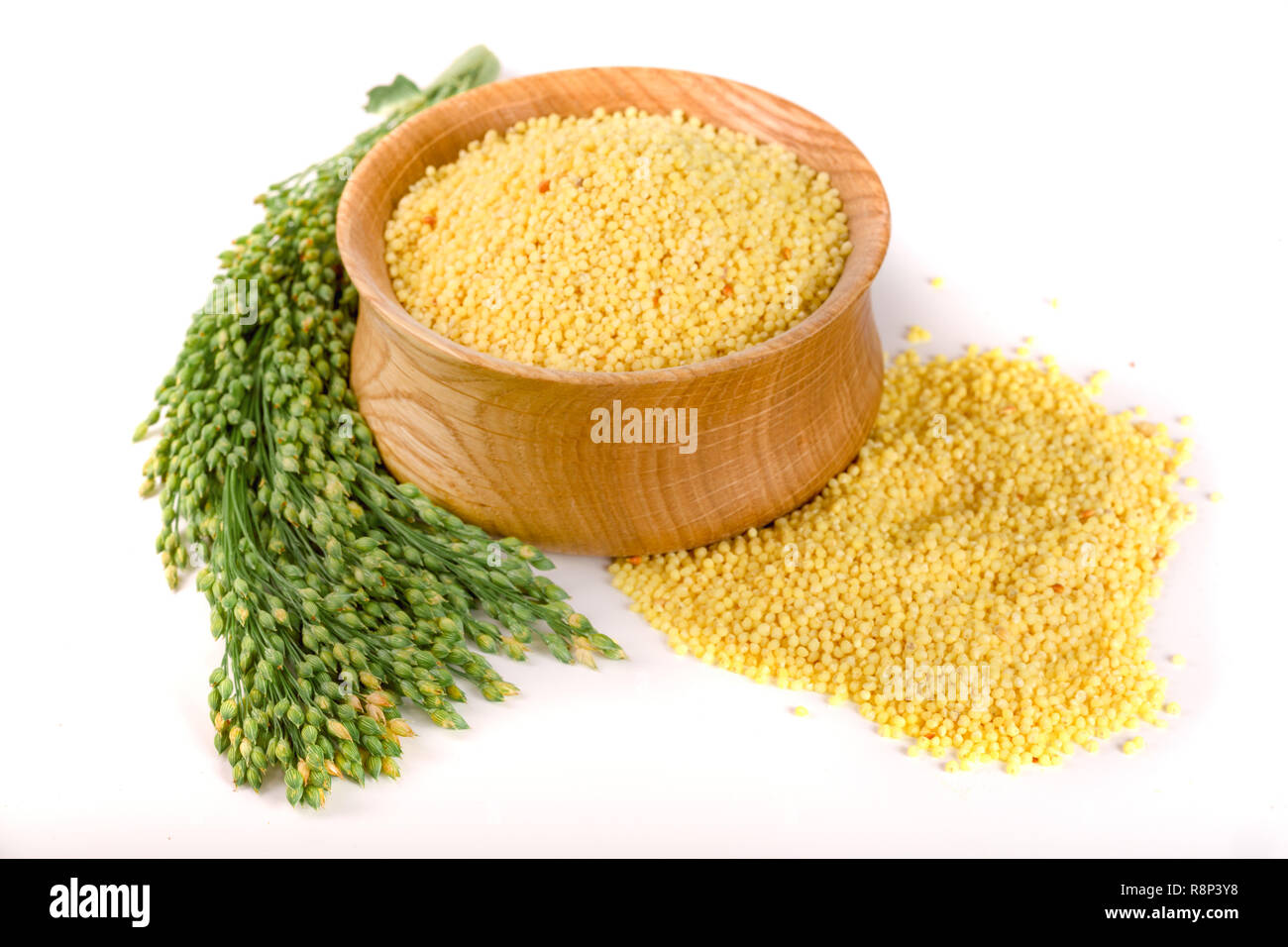 Millet dans bol en bois avec des épillets vert isolé sur fond blanc Banque D'Images
